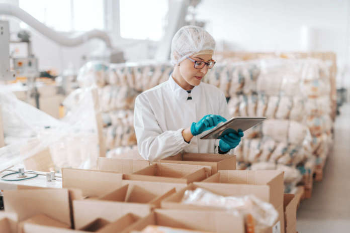 Young,Caucasian,Employee,In,Sterile,Uniform,Using,Tablet,For,Logistic.