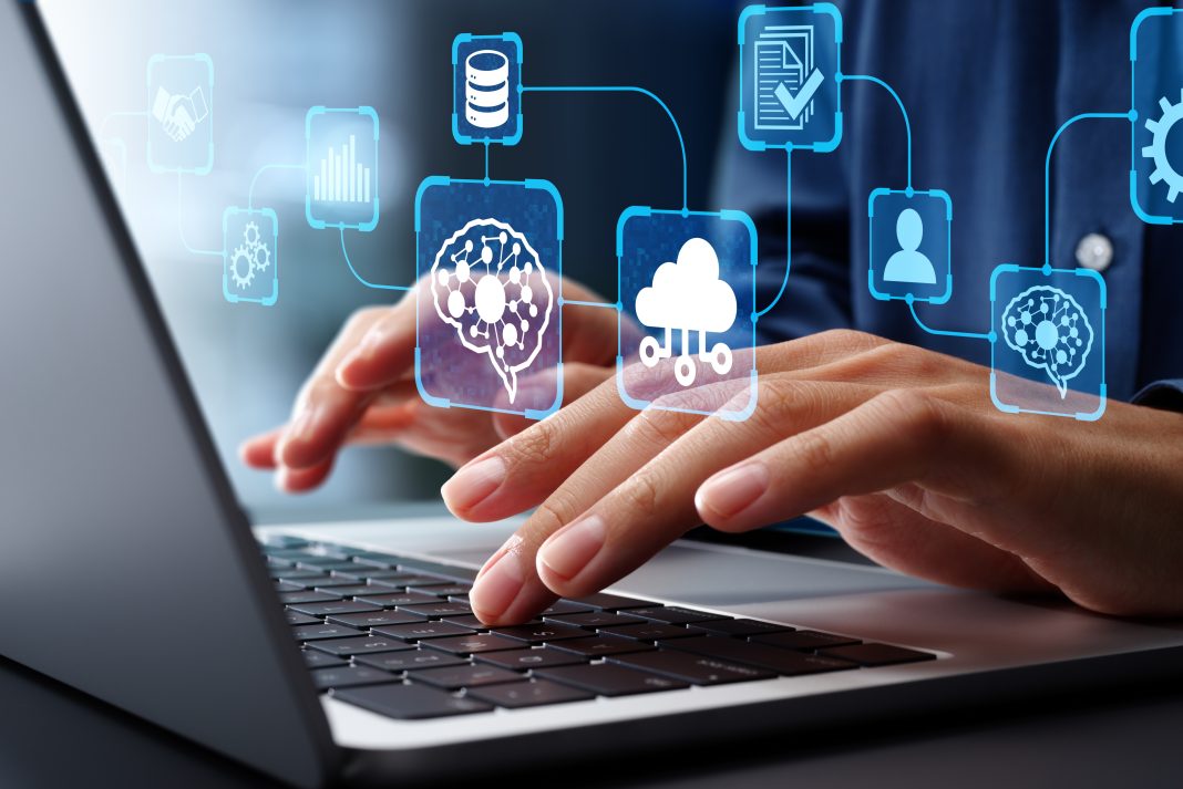 Mani che digitano su un laptop con icone digitali sovrapposte, rappresentazione visiva della digitalizzazione delle Pmi attraverso tecnologie cloud e gestionali integrati