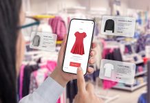 Private AI nel retail: sicurezza, performance e customer experience Utilizzo di private AI nel retail: Negozio di abbigliamento tramite un'app per smartphone con palloncini intorno che suggeriscono consigli sull'abbigliamento