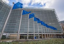 Antitrust nell’adtech: la Commissione europea multa Google per 2,95 miliardi di euro flags and Berlaymont Building