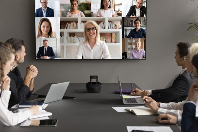 Marmitek Cam4KPro 1 Riunione aziendale ibrida con partecipanti in sala e in videoconferenza su grande schermo in video HD, grazie a una telecamera per conferenze professionale Marmitek