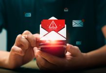 Persona che utilizza uno smartphone mentre compare un’icona di allerta malware su un’email, simbolo dei rischi legati al phishing e alla necessità del test del dominio per proteggere l’identità digitale aziendale