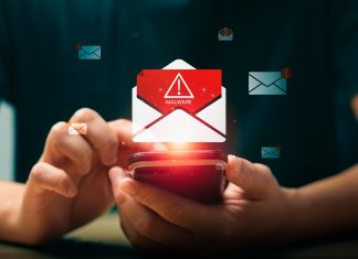 Persona che utilizza uno smartphone mentre compare un’icona di allerta malware su un’email, simbolo dei rischi legati al phishing e alla necessità del test del dominio per proteggere l’identità digitale aziendale