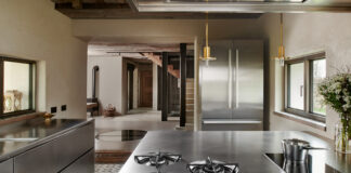 I blocchi operativi e il frigo in acciaio di Abimis arredano lo cucina della casa sulle Dolomiti