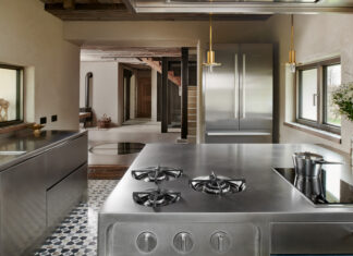 I blocchi operativi e il frigo in acciaio di Abimis arredano lo cucina della casa sulle Dolomiti