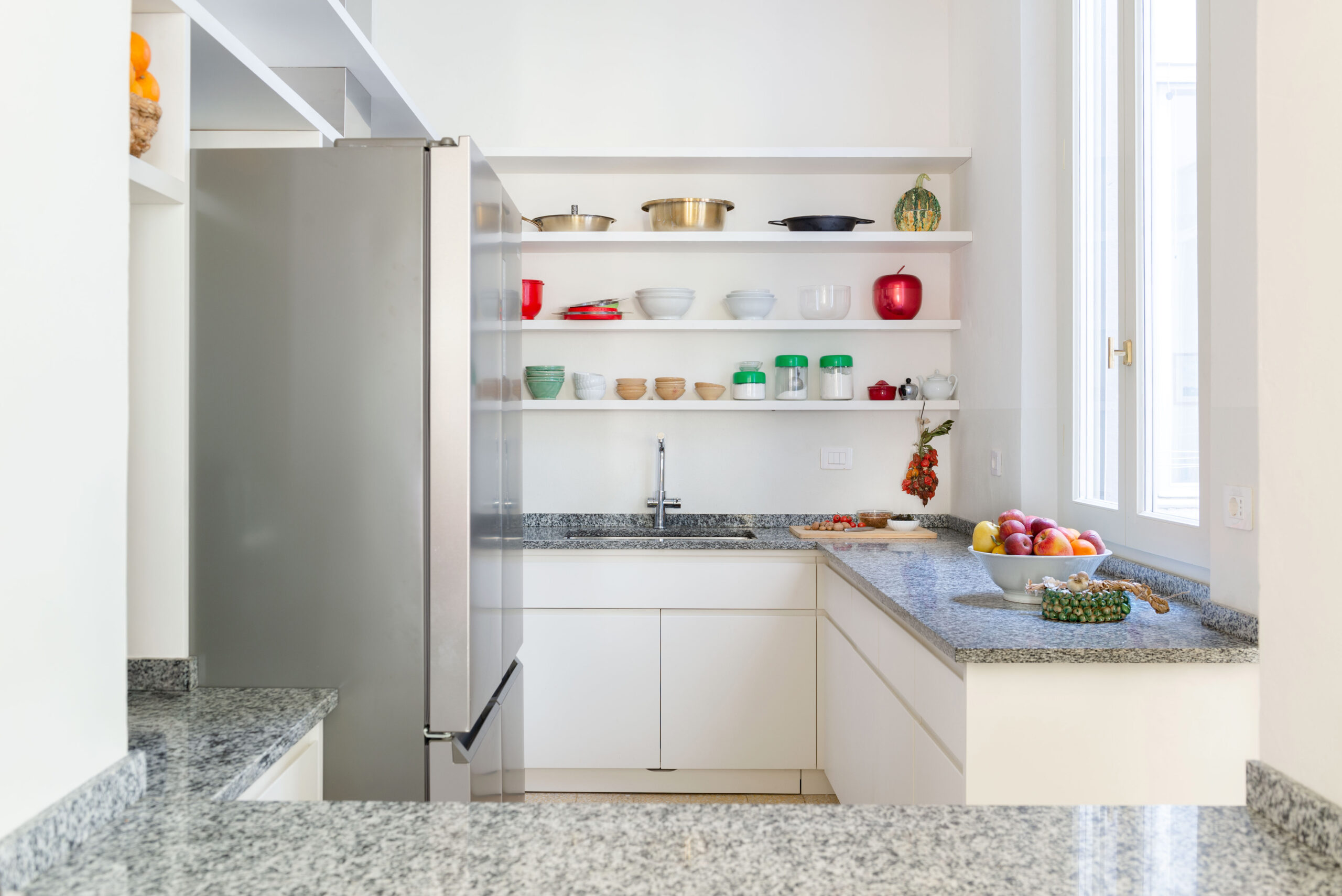 La cucina in laccato bianco ripresa dalla piano passante in granito