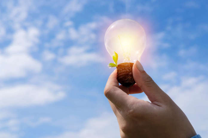 concept power energy in nature. hand holding lightbulb with sola Finanziamenti per l'efficientamento energetico