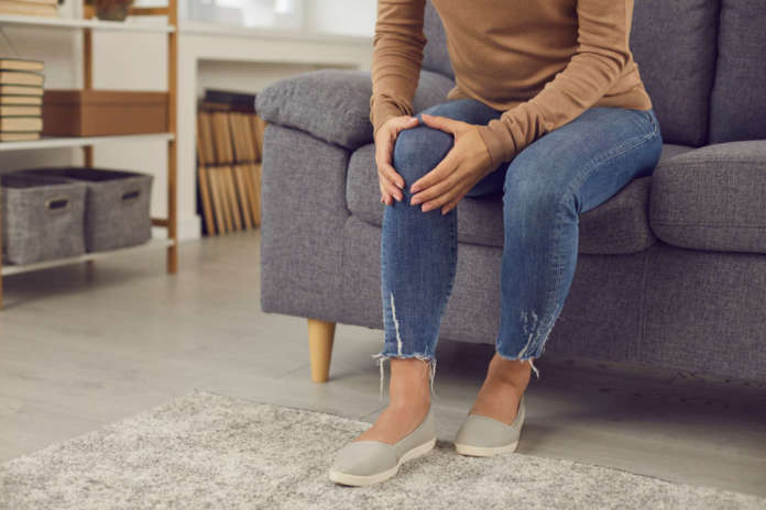 Woman who has rheumatic disorder or has hurt knee in home accident massaging her knee cap Infortuni domestici: modificati i ricorsi