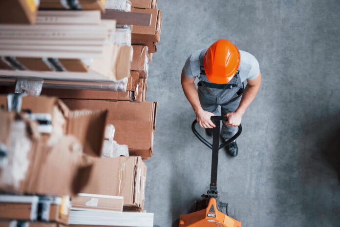 Top view of male worker in warehouse with pallet truck Anche la salute e la sicurezza nella legge