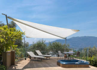 Vela ombreggiante tra palme e olivi