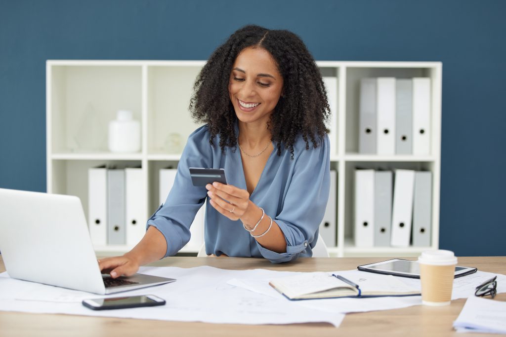Donna che utilizza la carta di credito al computer, agevolando i pagamenti digitali per architetti per snellire gli incassi