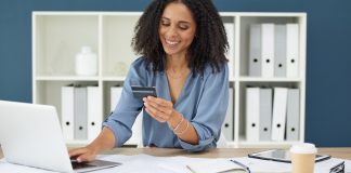 Donna che utilizza la carta di credito al computer, agevolando i pagamenti digitali per architetti per snellire gli incassi