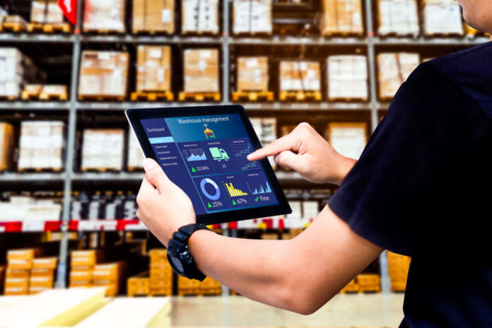 Smart warehouse management system.Worker hands holding tablet on grossisti