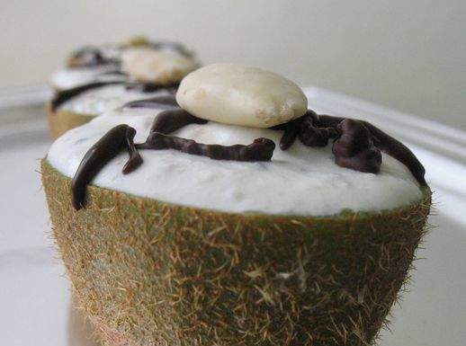 Un buon dessert di kiwi Kiwi ripieni con crema di ricotta all'arancia, mandorle e cioccolato
