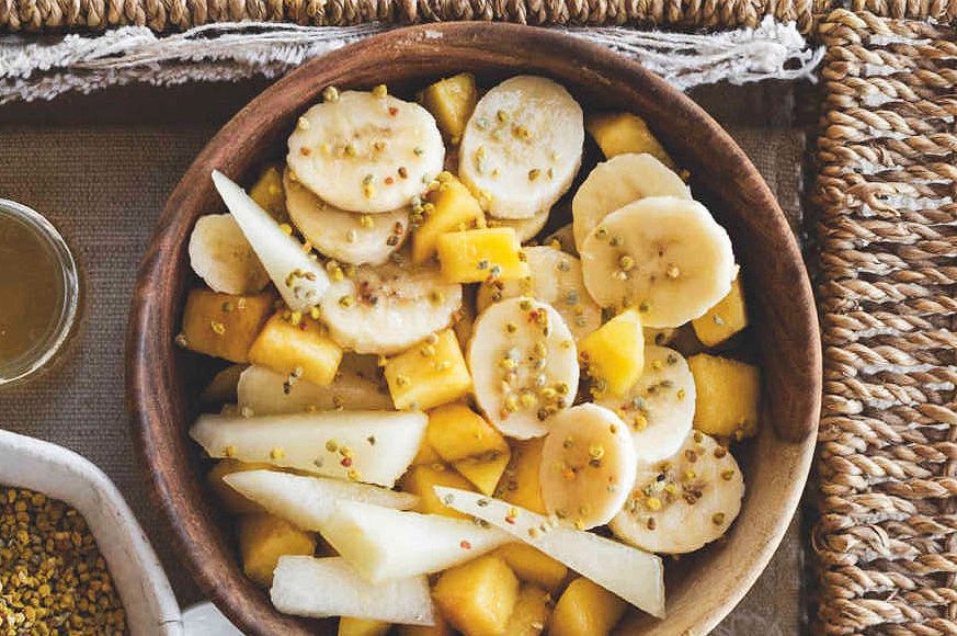 Macedonia di pesche, banane e melone bianco con miele e polline