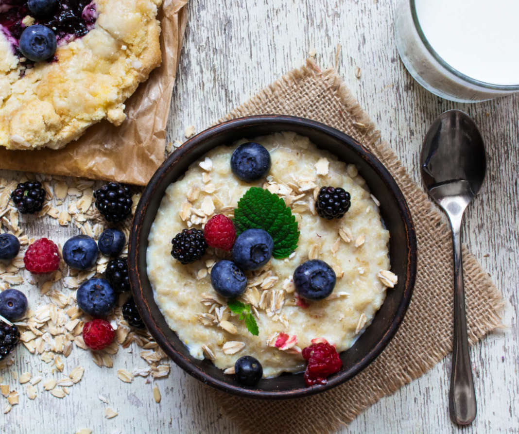 healthy breakfast with bowl of oatmeal, homemade blueberry cake and milk