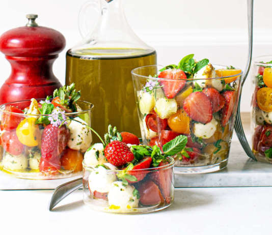 Bicchieri di caprese con fragole e pomodori