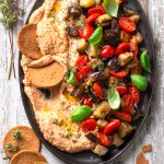 Caponata al basilico con datterini, hummus e cialde di riso