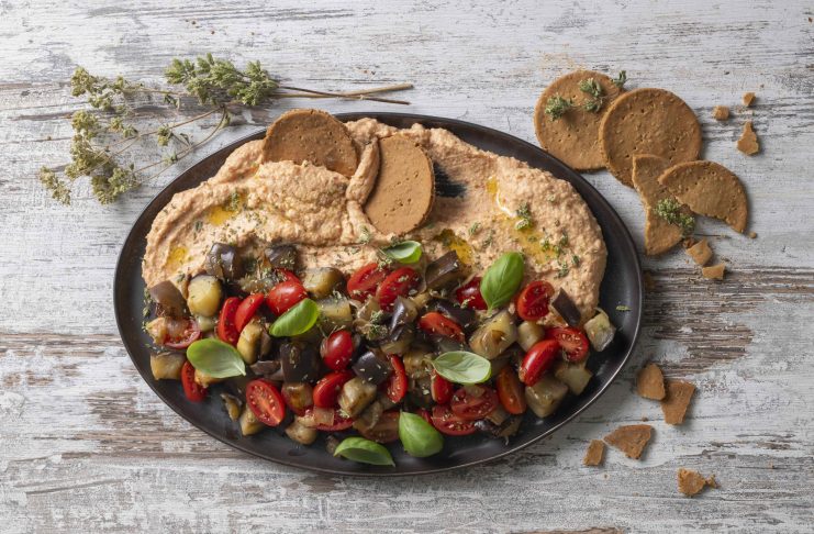 Caponata al basilico con datterini, hummus e cialde di riso