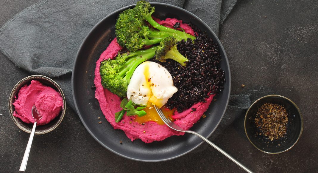 Bowl di riso venere con uova, broccoli, hummus alla barbabietola