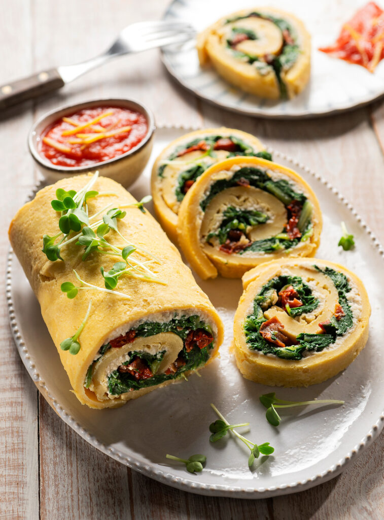 Rollè di farinata con crema di anacardi, erbette e pomodori