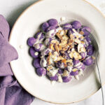 Gnocchi viola con fonduta al taleggio e mandorle tostate