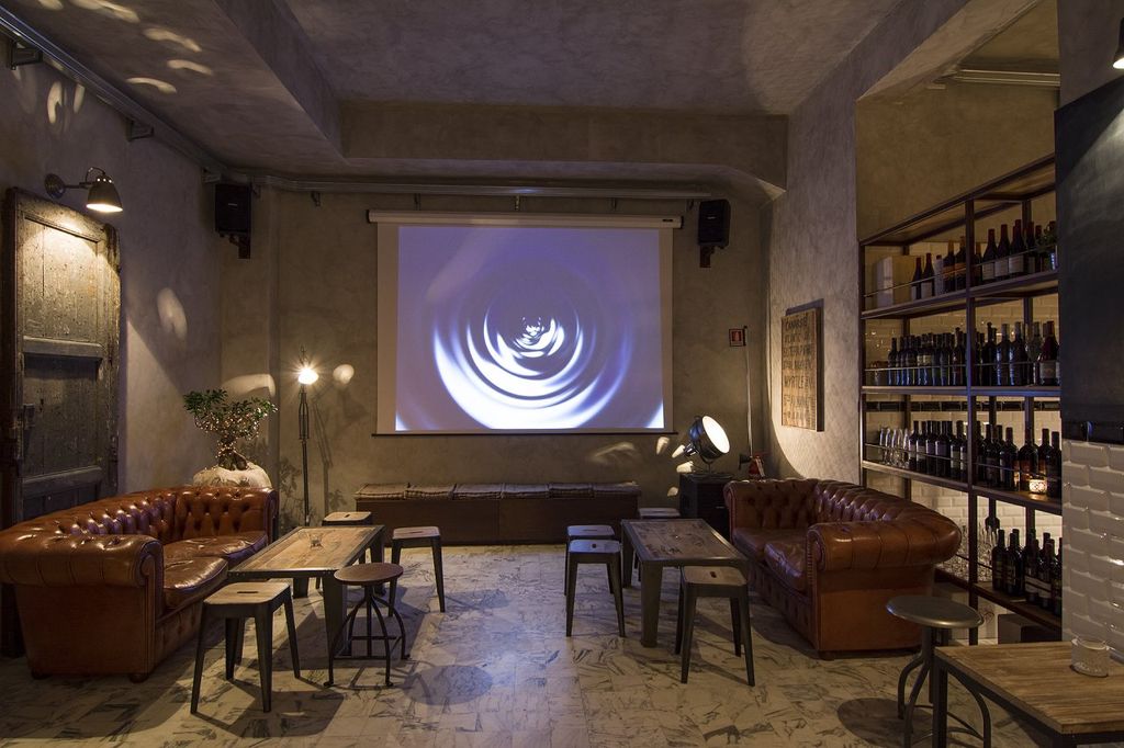 L’area privè, l’angolo più raccolto del locale, è allestita con divani chester in cuoio scuro, panche e sedute in ferro e legno di recupero