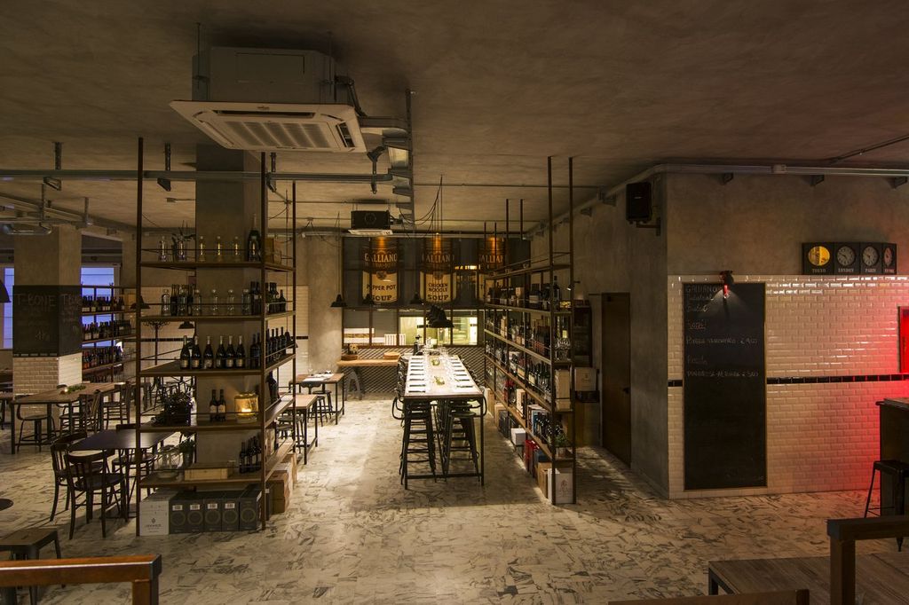L’area più conviviale del bistrot, quella riservata ai tavoli. In fondo alla sala la parete appesa, che separa la sala dalla zona cucina, realizzata con intelaiatura in corten