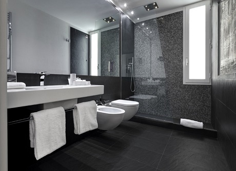 Il bagno di una delle stanze dell’Hotel Montecatini Palace con pavimento e pareti rivestite con In&Out Percorsi Style di Ceramiche Keope nei toni assoluti dell’Ardesia Nera, formato 30x60 centimetri