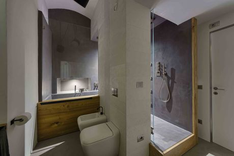Il bagno più grande è pensato come una spa, con una doccia da cui si può accedere, come in un percorso benessere, alla vasca. Bas-Relief di Mutina è la collezione di ceramica bianca che con effetti chiaroscurali, ripropone la matericità scabra del cemento (Alessio Gioana)