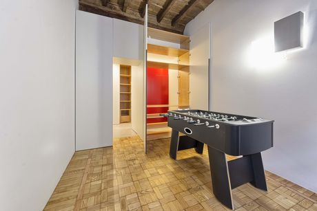 Un camera è organizzata a guardaroba e diventa una sala giochi. A terra, il pavimento a quadrotti di legno originale è stato conservato (foto Alessio Gioana)