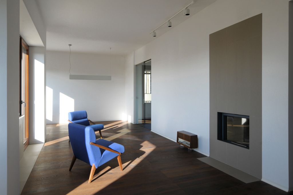 Il pavimento del soggiorno è rivestito a doghe di legno, tranne lungo il perimetro che porta ai terrazzi, dove invece è in gres (foto di Angelo Aloisi)