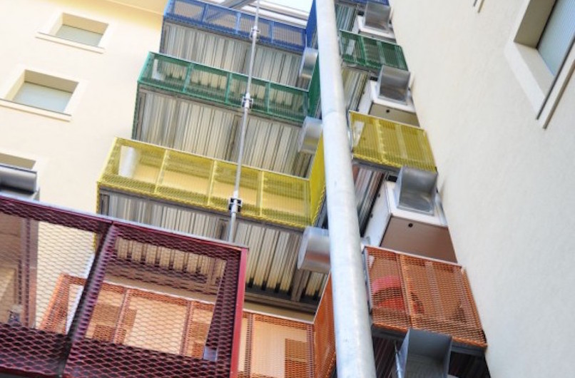 Ballatoi e scale di sicurezza sul fronte interno all'isolato sono tinteggiati con i colori che distinguono i piani (foto Luca Moretto)