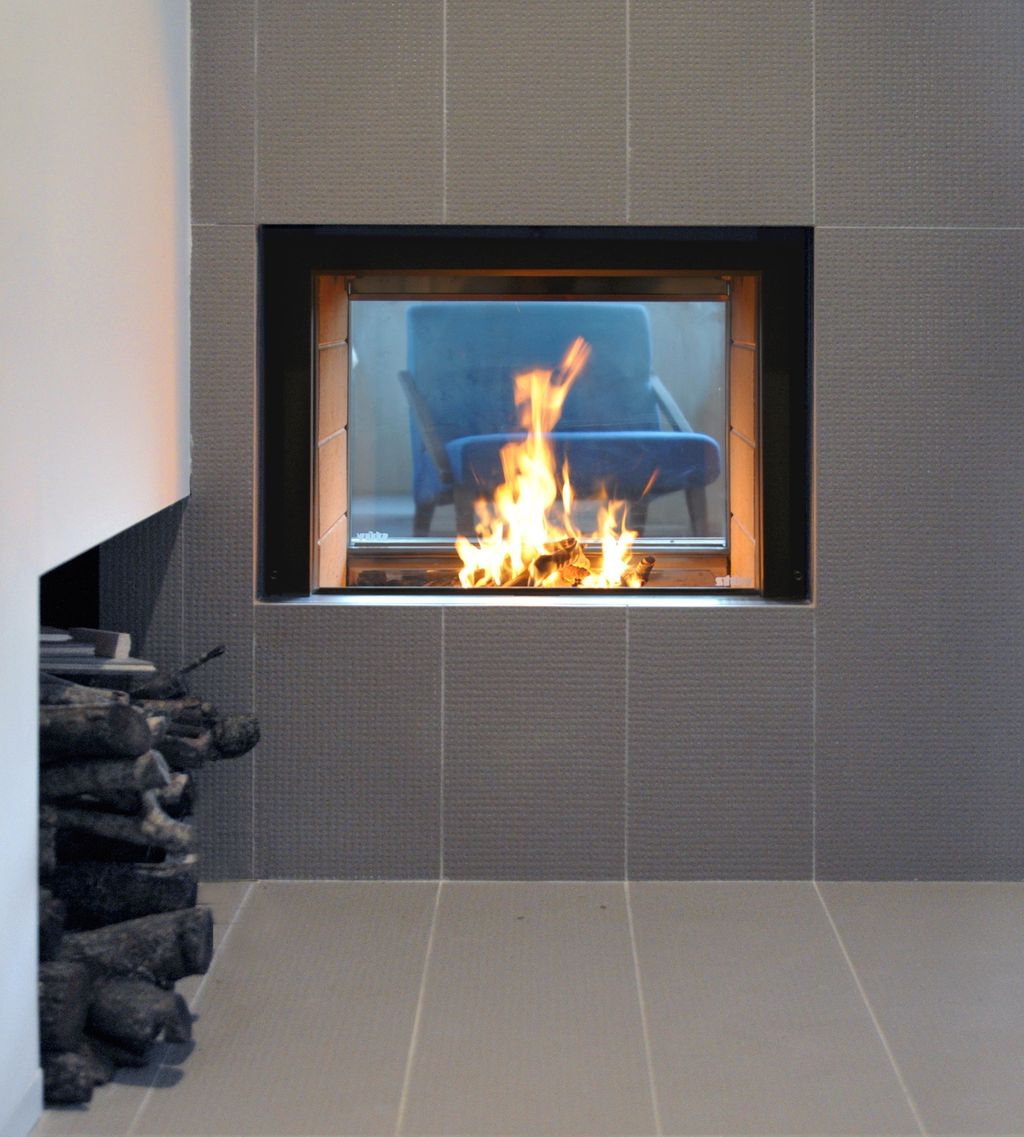 Particolare della cucina, con il camino passante e, sulla sinistra, il vano porta legna recuperato dal guardaroba d’ingresso (foto di Angelo Aloisi)