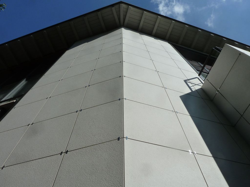 Dettaglio di facciata. Il rivestimento è realizzato in lastre di grès di colore grigio chiaro di 60x60 centimetri (foto Brianza Plastica)