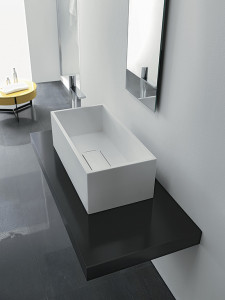 Il lavabo squadrato Deep, realizzato in Corian, ricorda una piccola vasca profonda che accoglie uno speciale scarico a “chiusino” filo lavabo con piastra realizzata nella stessa pietra acrilica. (foto Ponte Giulio)