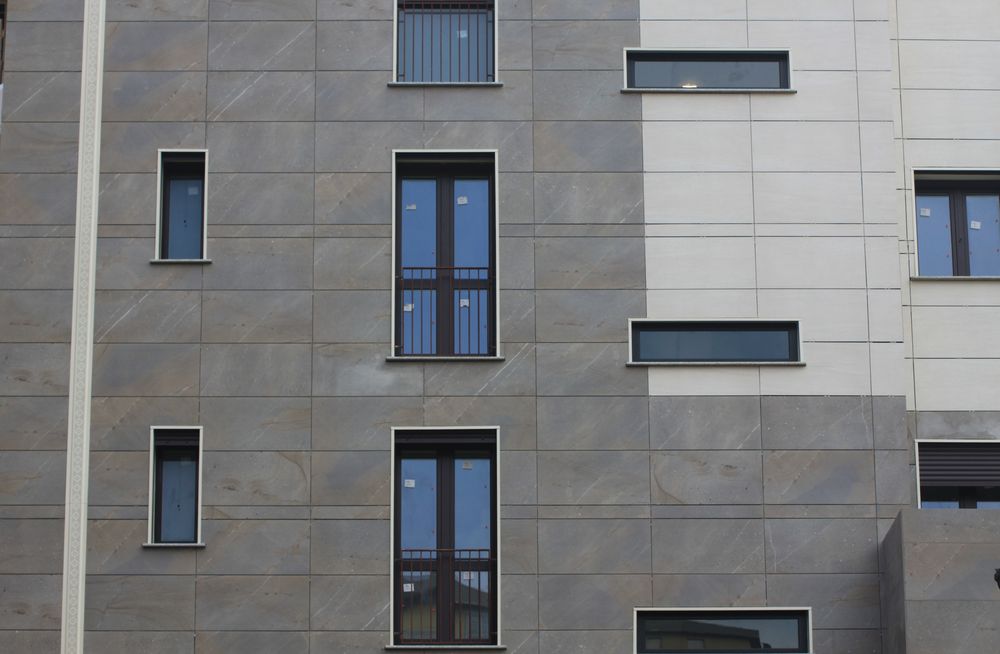 In questa facciata ventilata il sistema isolante portante Isotec Parete è abbinato a un rivestimento in lastre di gres in due colorazioni.