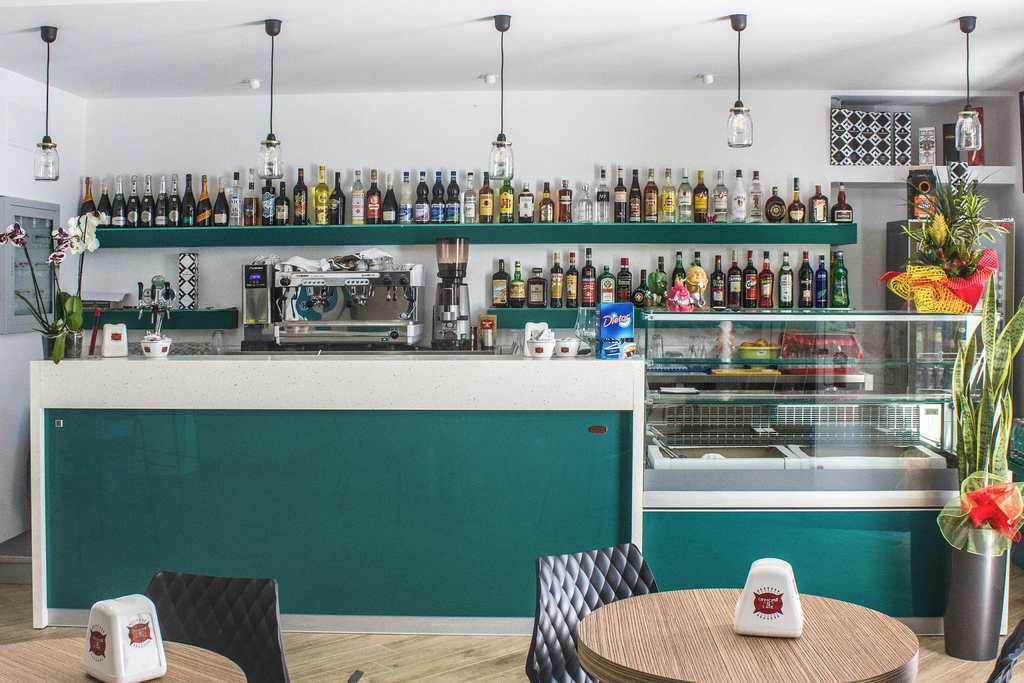 All'ingresso del Pub il grande bancone in acciaio rivestito in laminato simil marmo e legno laccato lucido (foto di Rosamaria Faralli)