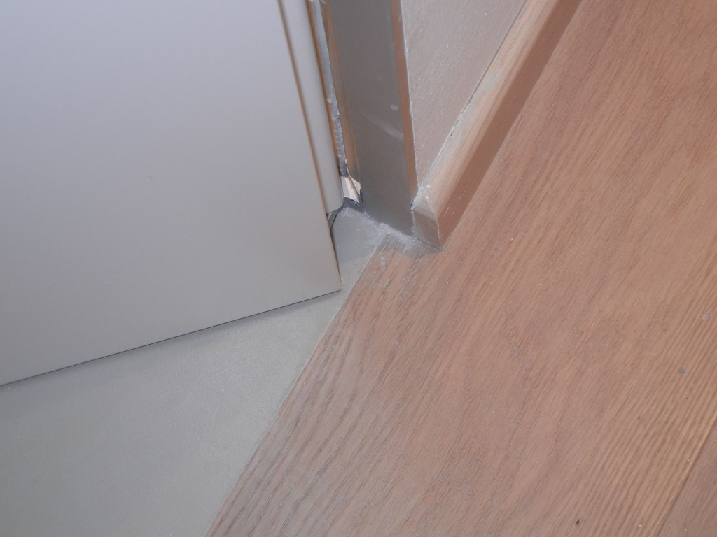 Posa di telai rasomuro in alluminio per porte a battente.