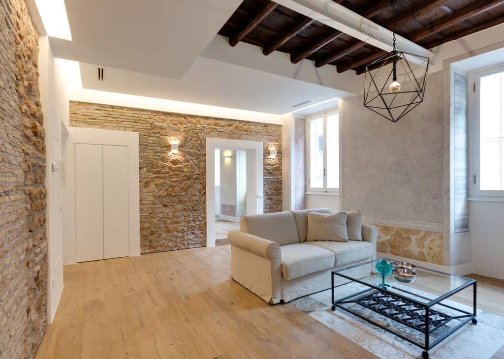 Lungo la parete scandita dalle finestre, gli affreschi a effetto marmo originali e restaurati. Nel centro della pavimentazione, sono state inserite piastrelle a marmette come piccoli tappeti (foto Vincenzo Giglio)