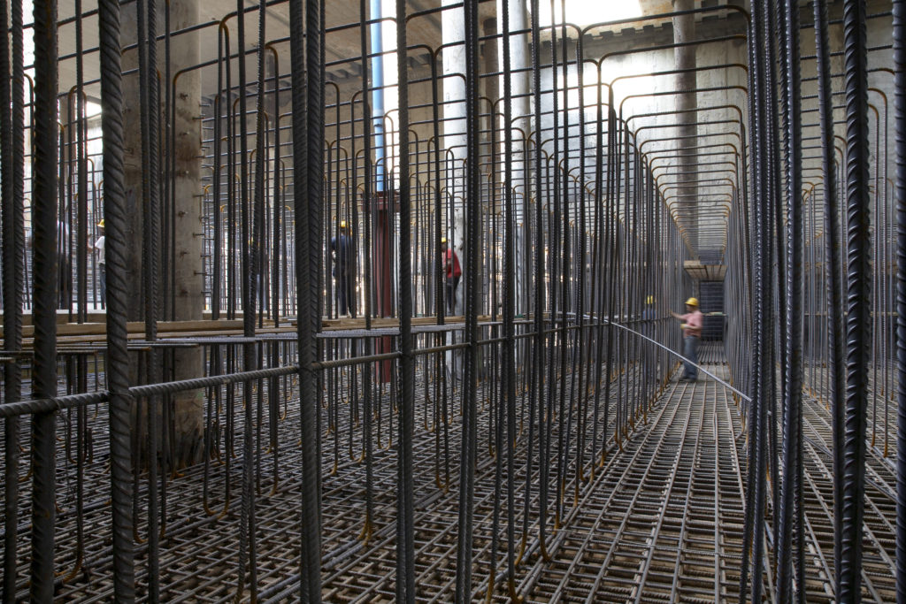 L'enorme platea, realizzata successivamente alla fase di top down, presenta una geometria importante. L’altezza delle carpenterie metalliche era tale da consentire il transito delle maestranze. Le particolari esigenze di contenimento del calore sviluppato hanno reso necessaria una miscela particolare, studiata appositamente, che consentisse anche il rispetto delle caratteristiche di autocompattabilità e una lavorabilità superiore alle sei ore (©Andrea Cappello).