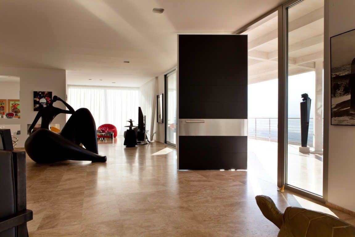 Per la porta d'ingresso scelto il modello Synua nella versione a 8 settori, rivestimento in rovere wengé valorizzato dalla presenza di un settore in acciaio.