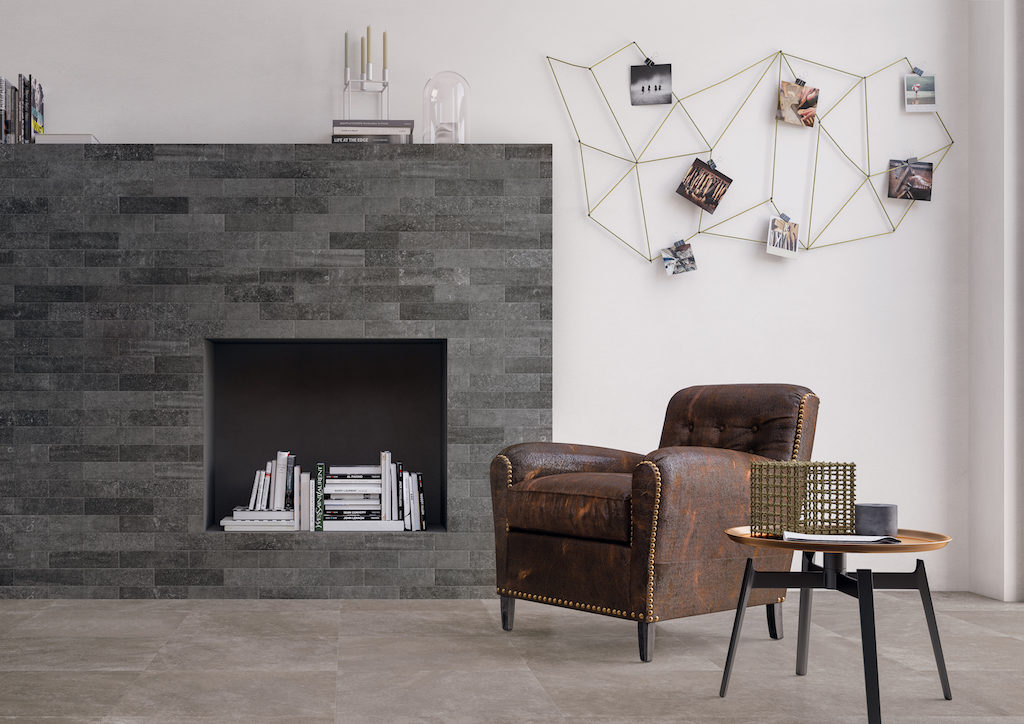 Moderno e raffinato angolo living realizzato con la nuova collezione di rivestimenti e pavimenti in gres porcellanato Brik. Per la parete del camino è stata impiegata Brik Back Anthracite cm. 7,5x30, mentre, per il pavimento, Code Taupe cm. 60x60Rt e finitura Matt. (foto Ceramica Keope)
