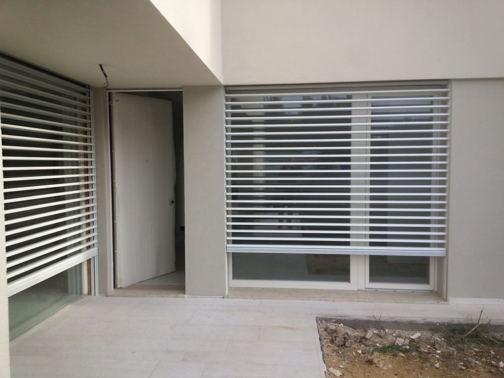 Il sistema di oscuramento è duplice, tende frangisole e oscuri scorrevoli esterni in alluminio.