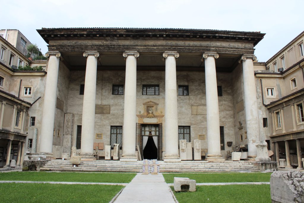 Il Teatro Filarmonico di Verona, situato a pochi passi da Piazza Bra, fu costruito tra il 1716 e 1729 su progetto dell’arch. Francesco Galli che realizzò un teatro moderno e maestoso, in legno laccato secondo l'imperante stile barocco. Il grandioso allestimento, però, andò in fiamme la notte del 1749, lasciandoci in memoria i progetti originali conservati dai reali inglesi nel castello di Windsor. Riscostruito già nel 1754 seguendo i progetti originali, nell'Ottocento riconquistò fama europea, per poi essere vittima dei bombardamenti angloamericani nel 1945. Nel dopoguerra il Filarmonico tornò a nuova vita su progetto dell’arch. Vittorio Filippini, che volle rappresentare le fattezze originali pur adeguandole alle moderne esigenze funzionali. Uno dei luoghi più suggestivi del teatro è il foyer, detto anche Sala degli Specchi, caratterizzato da numerosi specchi con stucchi dorati che inondano lo spazio di una luce abbagliante.