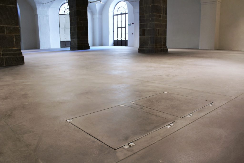 Chiusini Aco Uniface su pavimentazione con finitura in microtopping all’interno dello spazio espositivo per mostre temporanee (foto Aco)