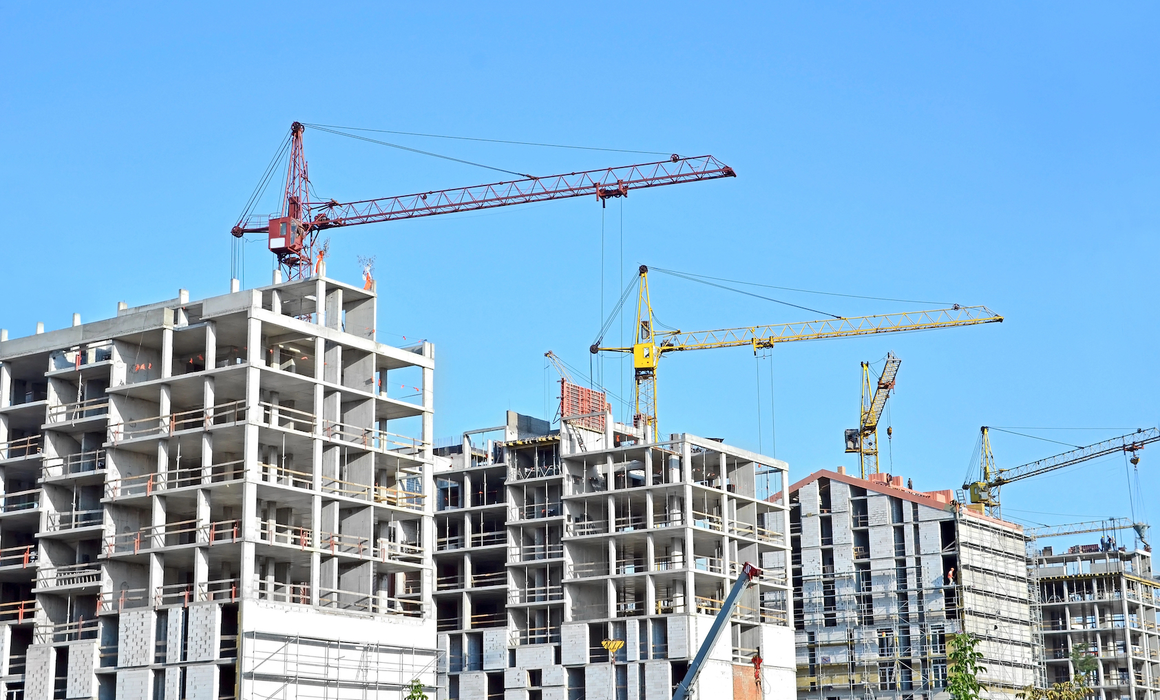 Crane and building construction site against blue sky