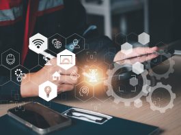 Primo piano di un impiantista che lavora su un tablet, circondato da icone digitali e ingranaggi che richiamano l'ingegneria, l'elettricità, il Wi-Fi, a simboleggiare i pagamenti digitali per impiantisti