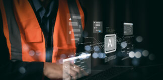 Tecnico con gilet di sicurezza che utilizza un laptop con interfacce di intelligenza artificiale per l'automazione dei processi amministrativi e la riconciliazione bancaria