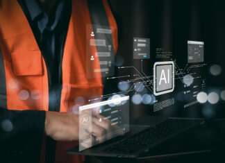 Tecnico con gilet di sicurezza che utilizza un laptop con interfacce di intelligenza artificiale per l'automazione dei processi amministrativi e la riconciliazione bancaria